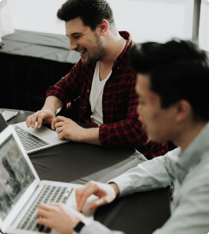 An image illustrating the core activities of 42 Company, featuring two men engrossed in their laptops while working.